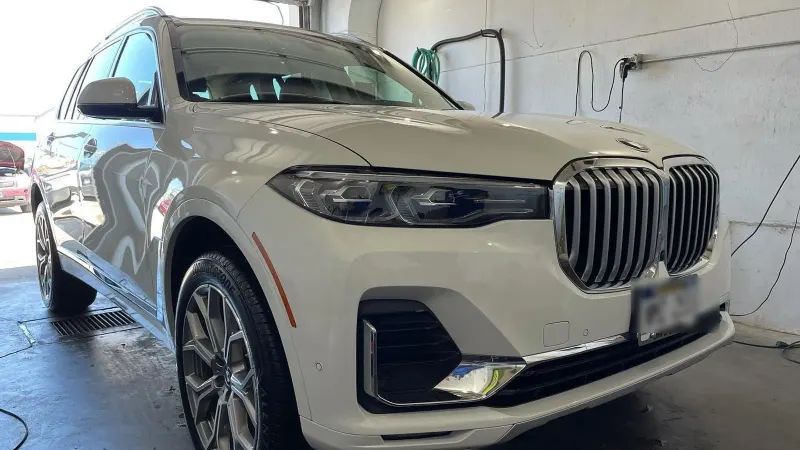 White BMW X7 with a glossy exterior after a full detail inside the Golden Auto Detailing studio in Lincoln